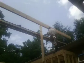 Carpenter setting a ridge beam over a new addition frame — Ice Dam Removal by Roofing Brothers in Maysville