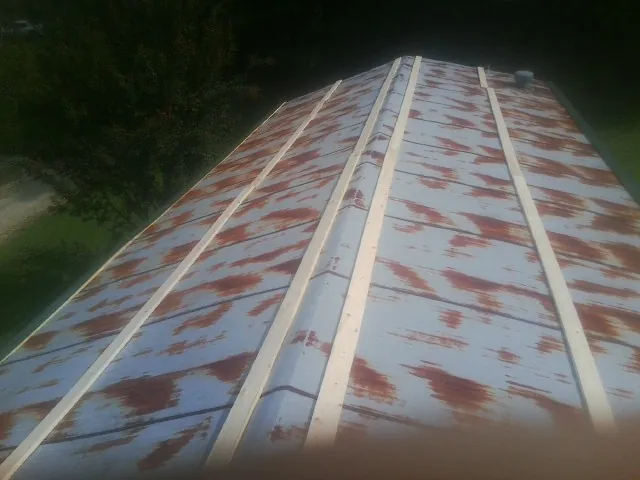 Rusted metal roof panels with new wood purlins before replacement — Storm Damage Roof Repair in Maysville by Roofing Brothers